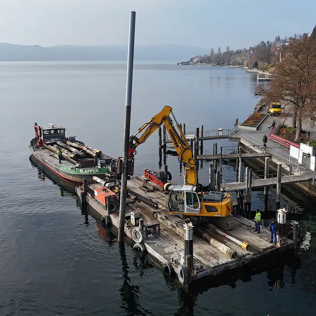 Bagger auf einem Ponton am Ufer