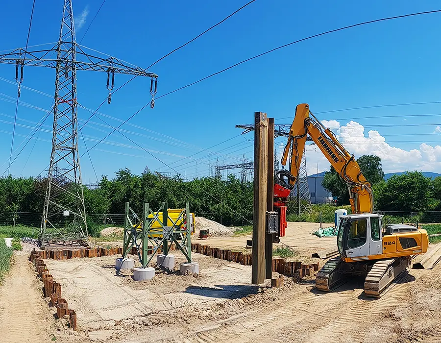 Bagger bringt Träger auf einer Spezialtiefbau-Baustelle ein
